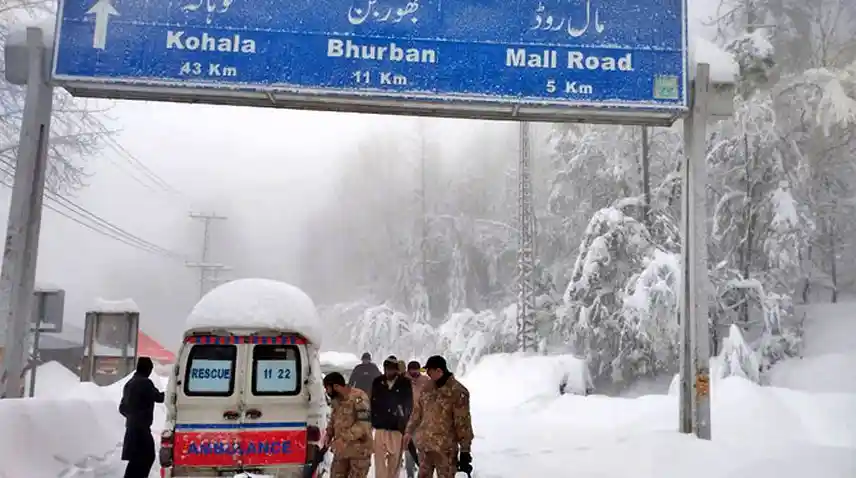 Snowcapped vehicles and hills during Murree snowfall
